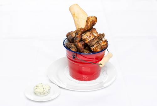 Hähnchenschenkel mit Baguette im roten Eimer